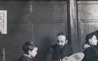 La photo montre Théodore Simon (assis avec les lunettes et la barbe) et Alfred Binet (debout) testant des enfants à l'École de la Grange aux belles à Paris,photo Archives de la Société Binet-Simon